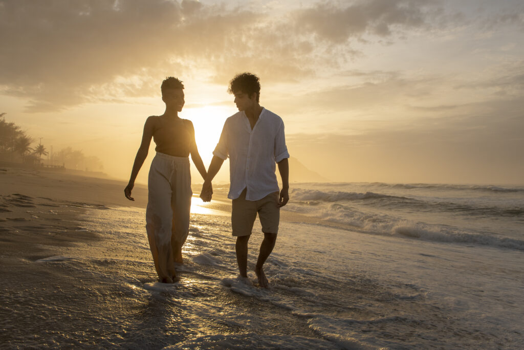 Married couple walking hand-in-hand toward a bright horizon, representing mutual commitment and accountability.