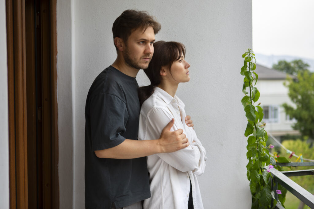 Husband and wife embracing in grace and reconciliation after a heartfelt moment.