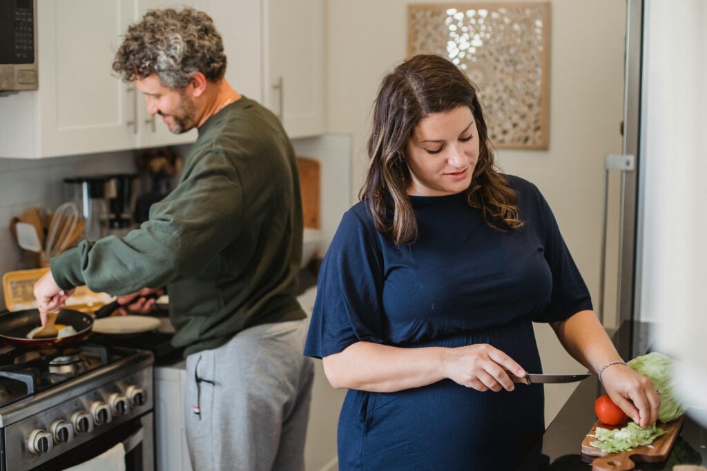 Married couple joyfully preparing a meal, enjoying everyday moments together.